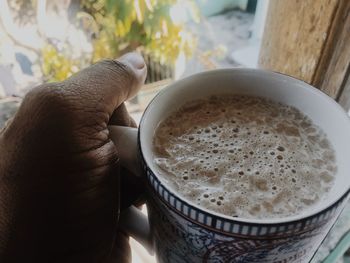 Close-up of hand holding coffee cup