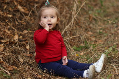 Portrait of cute girl sitting on field