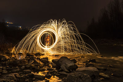 Man standing amidst illuminated wire wool