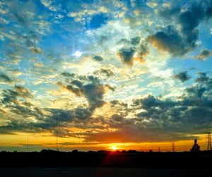 Silhouette landscape against dramatic sky during sunset