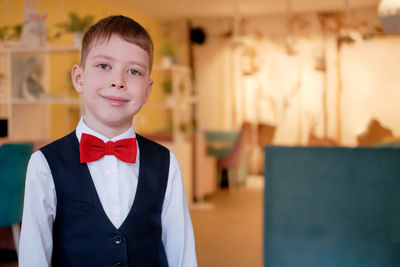 Portrait of a smiling boy in a white shirt and a red bow tie, copy spase