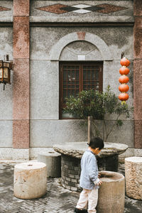 Rear view of man standing by building