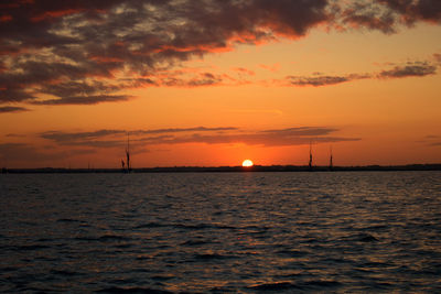 Scenic view of sea against dramatic sky during sunset