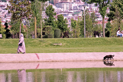 Woman walking by lake in city