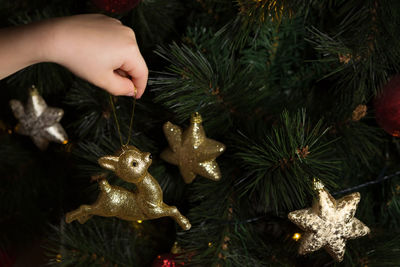 Cropped hand decorating christmas tree
