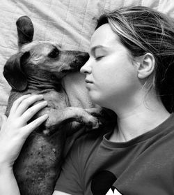 Directly above shot of woman with dog on bed at home