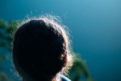 Close-up rear view of woman standing outdoors