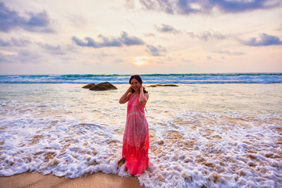 Young woman standing in sea waves. sky and sea beautiful sunset.