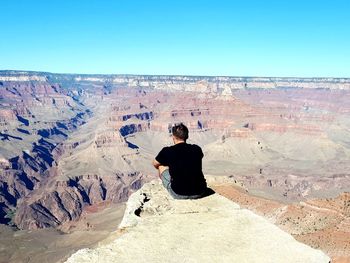 Rear view of man standing on rock