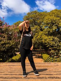 Full length of young woman standing against plants