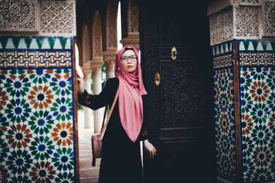 Woman standing at entrance of historic building