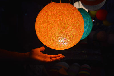 Close-up of hand holding orange laotian lantern