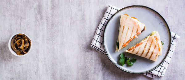 Grilled flatbread stuffed with avocado, mushrooms, tomatoes and parsley on a plate top view