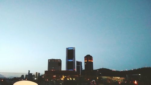 Low angle view of illuminated building against clear sky at night