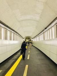 Rear view of people walking in subway station