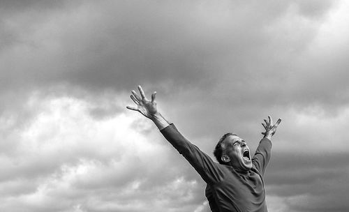 Man shouting with arms raised