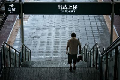 Rear view of man walking on steps