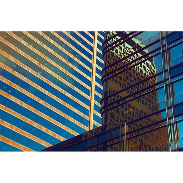 architecture, built structure, low angle view, building exterior, transfer print, modern, clear sky, auto post production filter, glass - material, city, building, office building, tower, sky, day, pattern, no people, tall - high, outdoors, grid