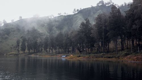 Scenic view of lake by trees against mountain