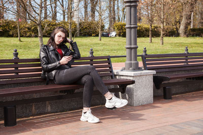 Woman sitting on bench in park