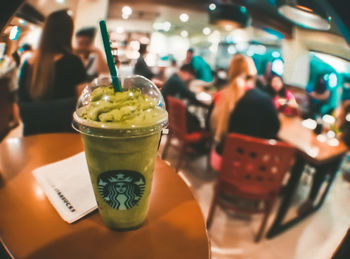 Close-up of woman holding drink in restaurant