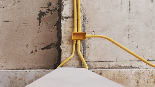 Close-up of yellow pipe on wall