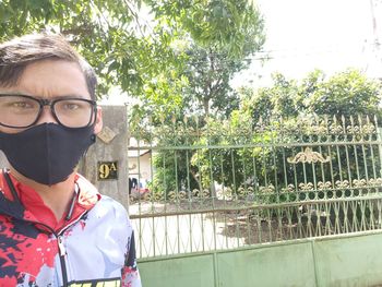 Portrait of young man standing against plants