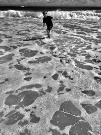 Boy running on shore at beach