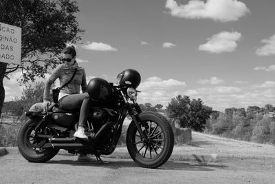 People riding motorcycle on road against sky