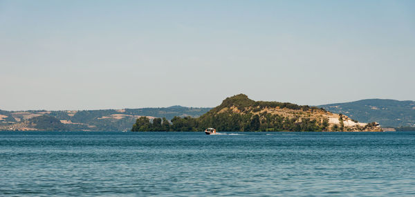 Scenic view of sea and mountains against clear sky