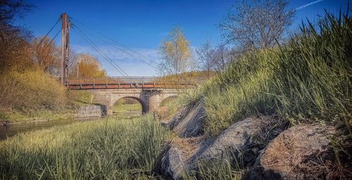 Arch bridge on field against sky