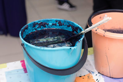 High angle view of paintbrushes in bowl on table