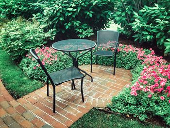 Empty chairs and table in yard