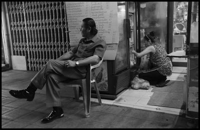 Side view of couple sitting on chair