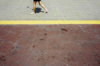 Low section of woman walking on zebra crossing