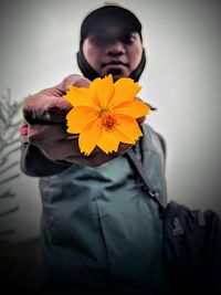 Beautiful woman standing by yellow flower