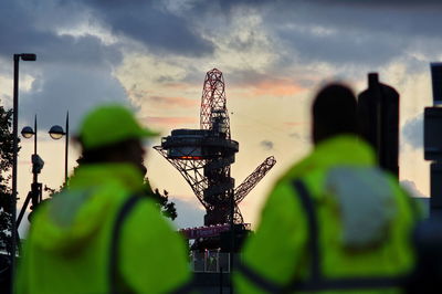 Rear view of workers looking at rig