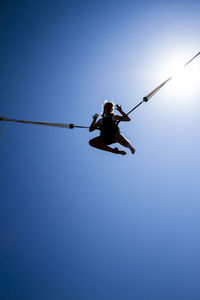 Low angle view of person paragliding against clear blue sky
