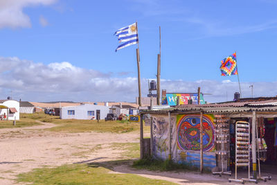 Low angle view of flags on buildings against sky