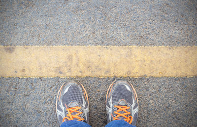Low section of person standing on road