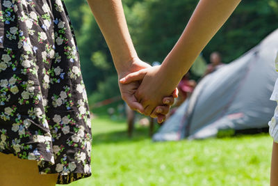 Cropped image of people holding hands at park