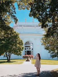 Full length rear view of woman standing against building