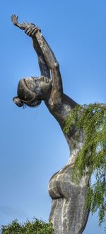 Low angle view of statue against clear blue sky