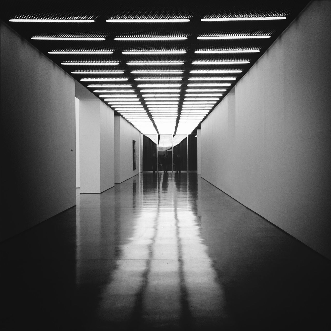 indoors, ceiling, corridor, illuminated, flooring, tiled floor, empty, architecture, built structure, lighting equipment, the way forward, absence, diminishing perspective, wall - building feature, floor, wall, tile, pattern, no people, interior