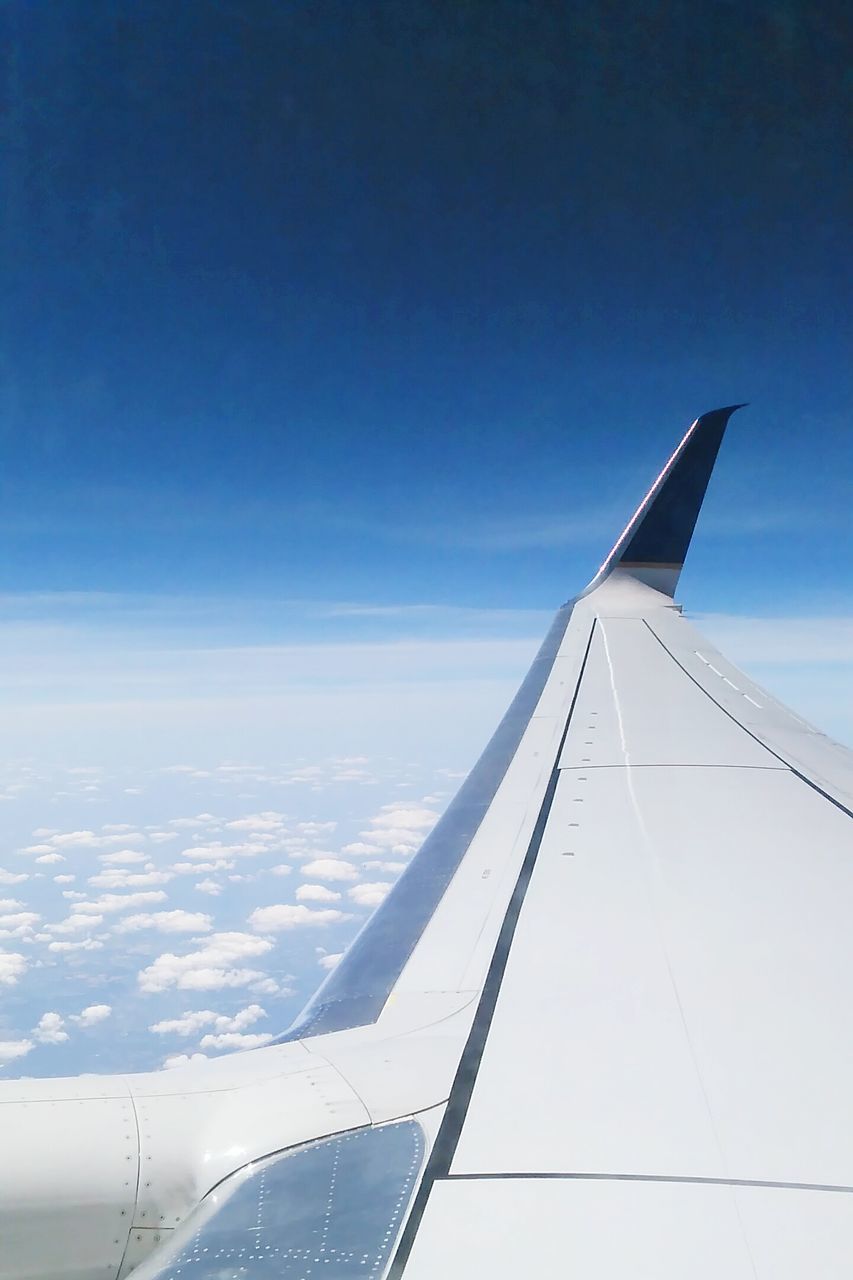 airplane, part of, cropped, blue, aircraft wing, flying, sky, transportation, air vehicle, clear sky, mid-air, travel, low angle view, day, outdoors, copy space, no people, aerial view, sunlight, white color