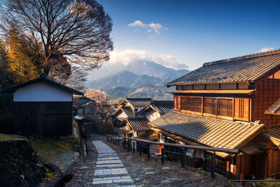 Houses by buildings against sky