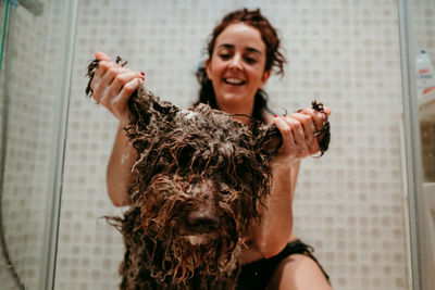 Smiling woman washing dog