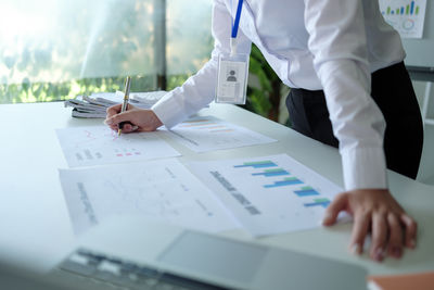 Midsection of businessman working on table