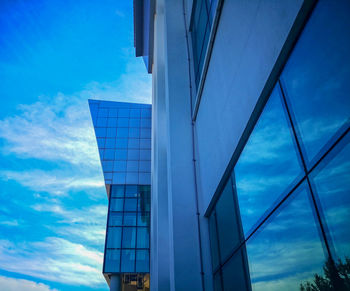 Low angle view of office building against blue sky