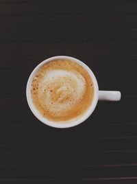 Close-up of cappuccino on table against black background